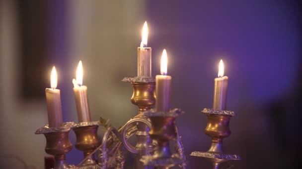 Las velas encendidas en hermosos candelabros. Fondo borroso — Vídeos de Stock