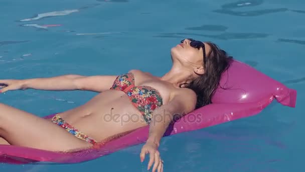 Krásná mladá žena, relaxaci v bazénu, v létě, ležící na nafukovací hale. Letní čas