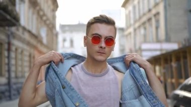 Kot yelek ve kırmızı güneş gözlüklü adam sokakta yürürken fırtınası