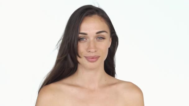 Superbe jeune femme aux cheveux longs et aux taches de rousseur aux épaules nues pose pour une caméra — Video