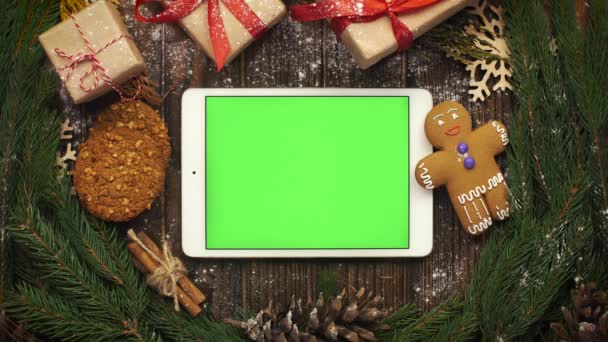 Van bovenaf kijken tablet met groen scherm liggen onder Christma — Stockvideo