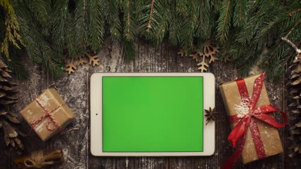 クリスマス ツリーの中で横になっている緑の画面とタブレットを上から見てください。 — ストック動画