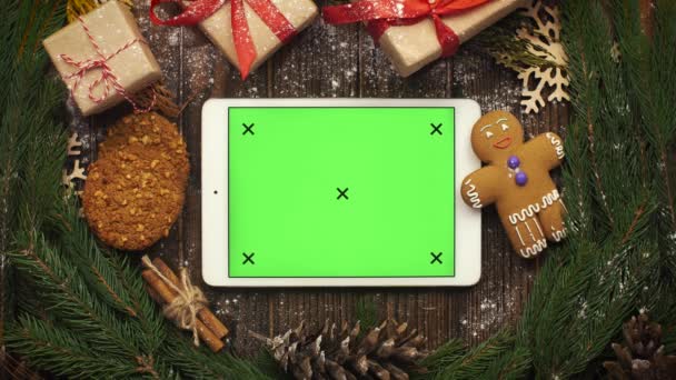 Kig ovenfra på tablet med grøn skærm liggende blandt Christma – Stock-video