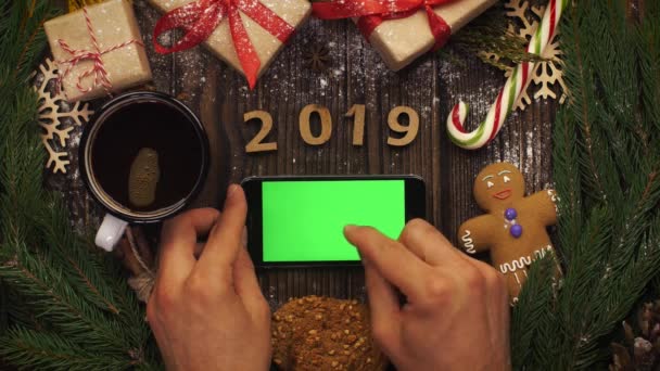 Κοιτάξτε από ψηλά ξύλινα γράμματα 2019 και smartphone με g — Αρχείο Βίντεο