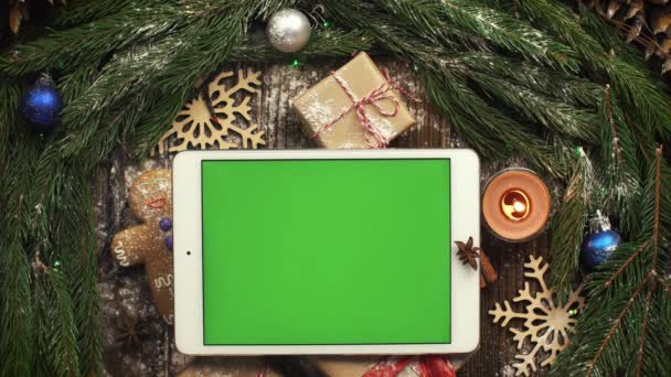 Van bovenaf kijken tablet met groen scherm liggen onder Christma — Stockvideo