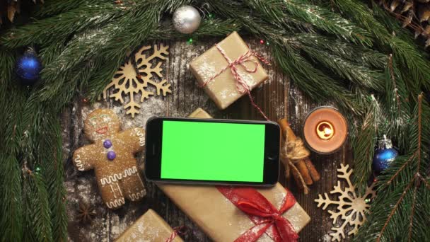 Ser från ovan på tablet med grön skärm liggande bland jult — Stockvideo