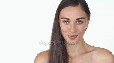 Çarpıcı genç kadın uzun saçlı ve beyaz arka plan üzerinde çıplak omuz gülümsüyor utangaç duran