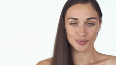 Çarpıcı genç kadın uzun saçlı ve beyaz arka plan üzerinde çıplak omuz gülümsüyor utangaç duran