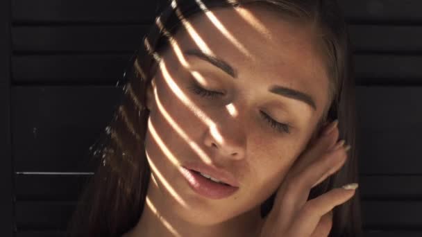 Rayons de lumière du soleil reposent sur le visage des femmes alors qu'elle touche son visage tendre — Video