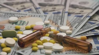 Ampul ve hapları bir masada dolar ile yalan. Bir insan eli yukarıdan iğneyle bir şırınga koyar. Uyuşturucu bağımlılığı veya sağlık kavramı