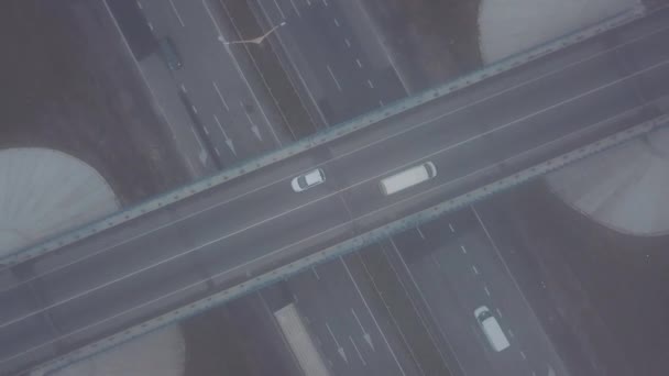 Luftaufnahme vertikal mit Rotation. Autos, die auf der Straße fahren. Verkehrsknoten. Autos fahren unter und über der Brücke. Dichter Nebel — Stockvideo