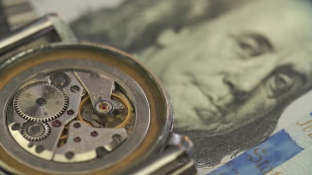 Nahaufnahme des Uhrwerksantriebs in einer edlen Uhr auf der Dollarnote — Stockvideo
