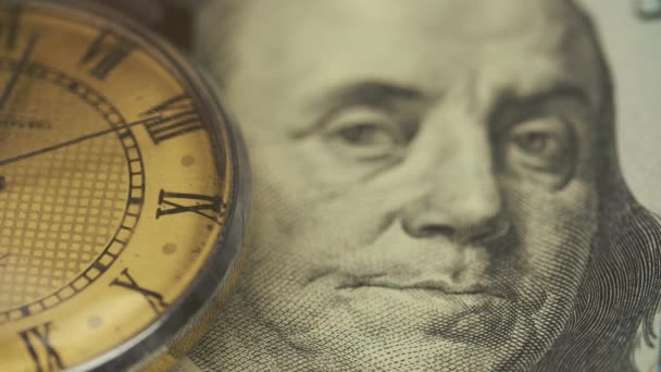 El viejo reloj yace sobre la mesa en un billete de cien dólares — Vídeos de Stock