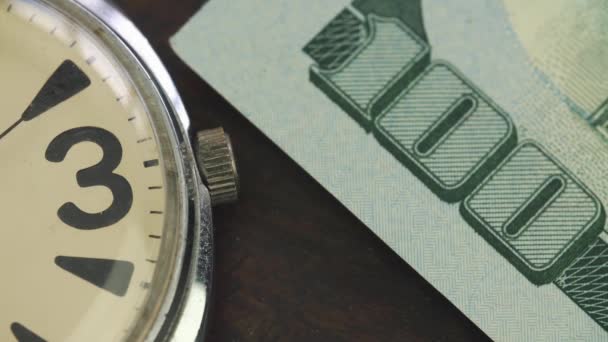 Παλιό ρολόι βρίσκεται στο τραπέζι των διαπραγματεύσεων σε onde εκατό δολαρίων τραπεζογραμματίων — Αρχείο Βίντεο