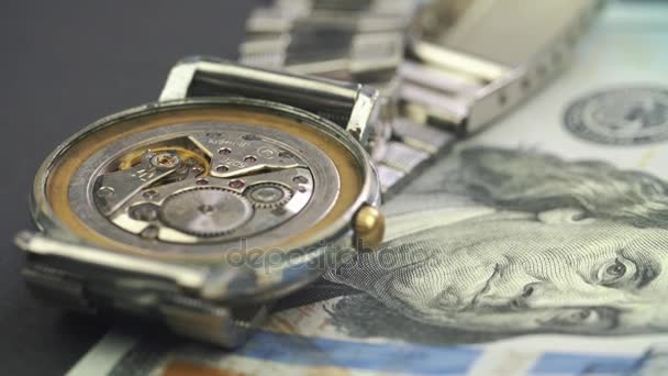 Gros plan sur le lecteur d'horlogerie dans une montre chic sur le billet en dollar 