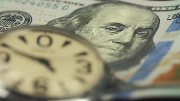 El viejo reloj yace sobre la mesa en un billete de cien dólares — Vídeo de stock