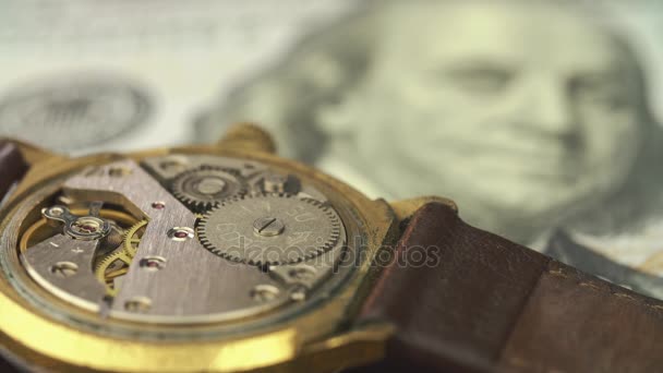 Primer plano de la unidad de relojería en un reloj con clase en el billete de dólar — Vídeos de Stock