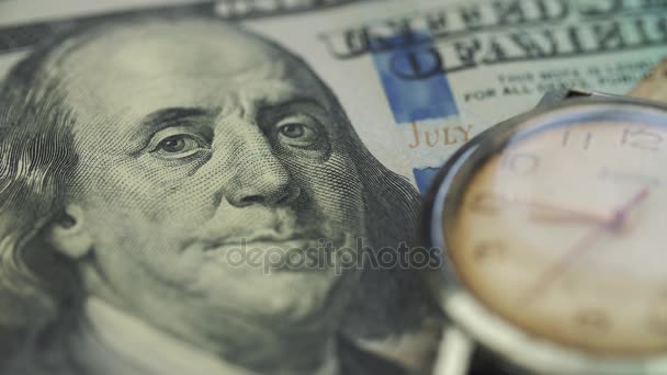 Eski saati onde masaya yüz dolarlık banknot yatıyor — Stok video