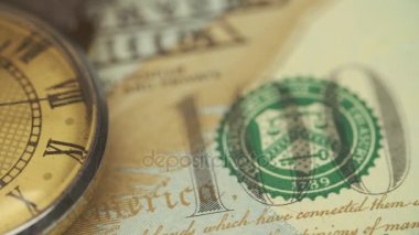 Eski saati onde masaya yüz dolarlık banknot yatıyor