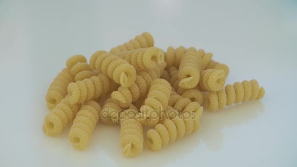 Closeup of dry maccheroni lying on the table. The frame rotates clockwise. — Stock Video