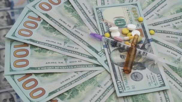 Drugs en pillen voor verslaving liggen op de duizenden dollars van het papier. Het frame draait tegen de klok in. — Stockvideo