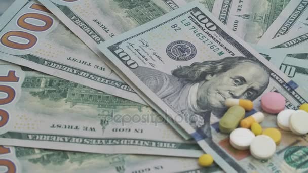 Las drogas y las píldoras para la adicción se encuentran en los miles de dólares de papel. El marco gira en sentido contrario a las agujas del reloj . — Vídeo de stock