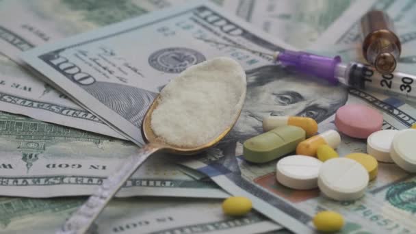Наркотики и таблетки от наркомании лежат на тысячах бумажных долларов — стоковое видео