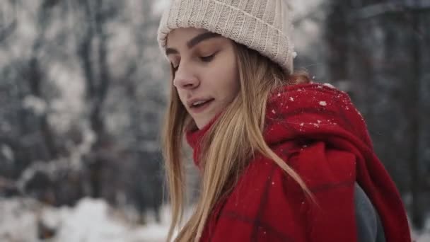 Jeune belle fille en vêtements chauds marchant près des arbres de Noël. Au ralenti. Portrait de jeune fille élégante et belle dans un parc d'hiver — Video