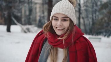 Noel ağaçları yürüyüş sıcak giysiler içindeki genç güzel kız içinde. Ağır çekim. Bir kış parkta şık genç güzel kız portresi