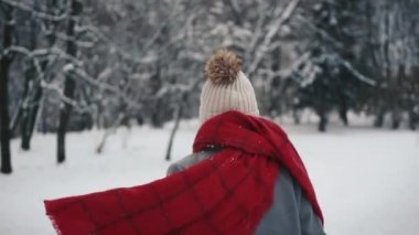 Noel ağaçları çalışan ve kameraya yavaş seyir sıcak giysiler içindeki genç güzel kız içinde. Bir kış parkta şık genç güzel kız portresi