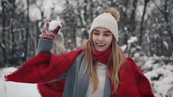 Young Active Woman is Throwing Snowball at the Camera Having Fun Outdoors during Winter Time — Stock Video