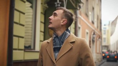 bir bulutlu havalarda sokakta yürürken bir pelerin genç bir işadamı. Ağır çekim