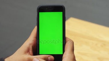 Dikey smartphone ile yeşil ekran kullanan adam. Yakın çekim çekim cep telefonu ile el mans. Chroma anahtar. Yakın çekim. Dikey