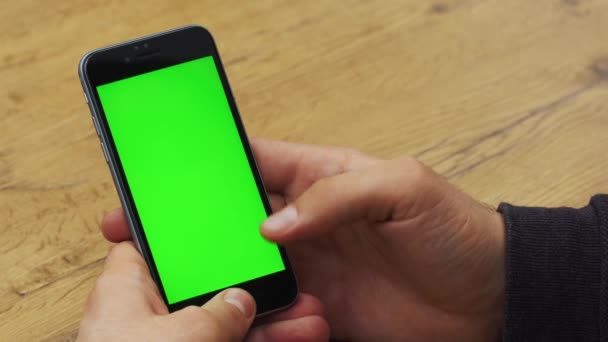 Homem usando smartphone vertical com tela verde. Tiro de perto de mãos de homem com telefone celular. Chave Chroma. Fecha. Vertical — Vídeo de Stock