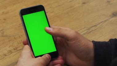 Dikey smartphone ile yeşil ekran kullanan adam. Yakın çekim çekim cep telefonu ile el mans. Chroma anahtar. Yakın çekim. Dikey