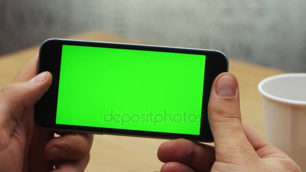 Uomo che utilizza smartphone orizzontale con schermo verde. Primo piano di mani di uomo con il telefono cellulare. Chiave cromatica. Chiudete. Orizzonte — Video Stock