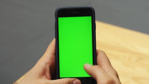 Человек с вертикальным смартфоном с зеленым экраном. Крупный план рук человека с мобильным телефоном. Хрома-ключ. Закрывай. Вертикаль — стоковое видео