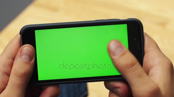 Uomo che utilizza smartphone orizzontale con schermo verde. Primo piano di mani di uomo con il telefono cellulare. Chiave cromatica. Chiudete. Orizzonte — Video Stock