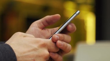 Close-Up bir şey üstünde smartphone yazarak eller mans
