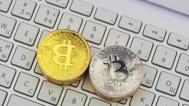 Guld och Silver Bitcoins roterande på silver tangentbordet. Digitala mynt btc pengar krypto valuta — Stockvideo