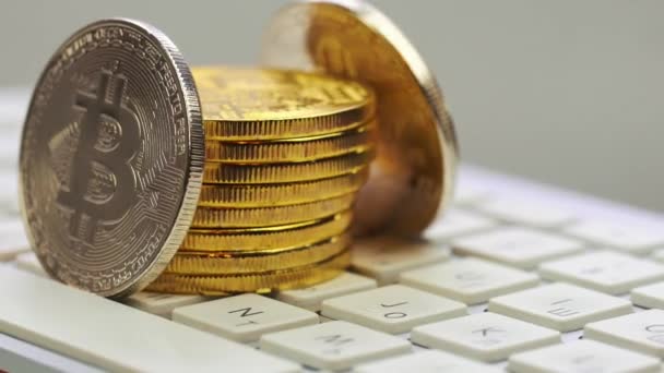 Gold- und Silberbitcoins rotieren auf der silbernen Tastatur. Digitalmünze btc Geld Kryptowährung — Stockvideo