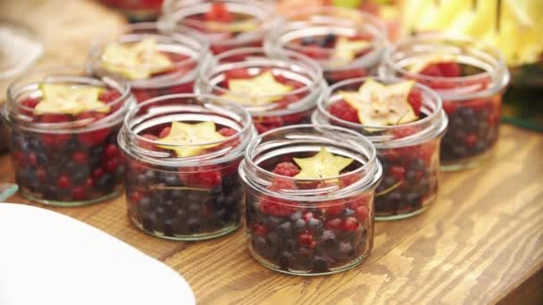 Någon serverar frukter i glasskålar på candy bar — Stockvideo