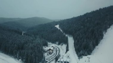Dağlar, ormanlar ve küçük kasaba kışın karla kaplı üst bakmak