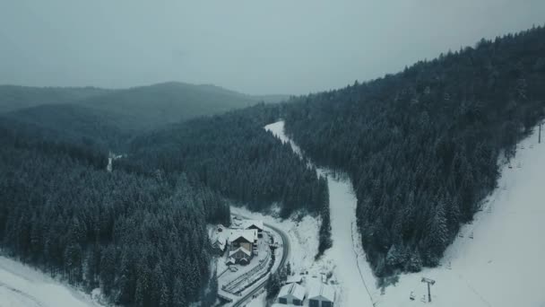 Podívejte se z vrcholu na hory, lesy a malá města zavátá sněhem v zimě — Stock video