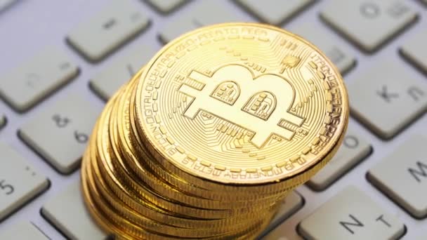 Gold-Bitcoin rotiert auf der silbernen Tastatur. Digitalmünze btc Geld Kryptowährung — Stockvideo