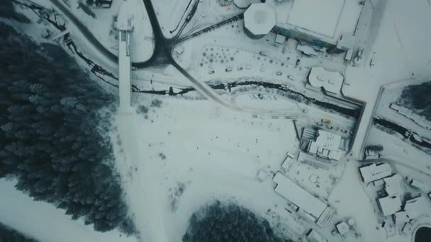 Mira desde lo alto de las montañas, bosques y pequeños pueblos cubiertos de nieve en invierno — Vídeo de stock