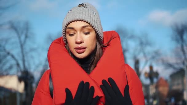 Mulher bonita em jaqueta de inverno vermelho caminha ao longo da rua coberta de neve em uma bela cidade europeia velha — Vídeo de Stock