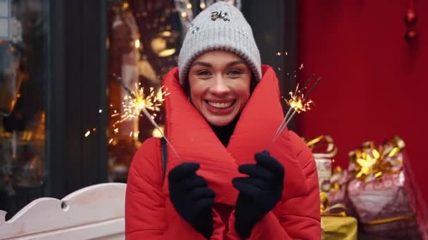 Menina alegre com fogos de Bengala fica na rua de uma antiga cidade de inverno — Vídeo de Stock