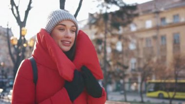 Sokakta bir güneşli kış günü kar ile kaplı bir kırmızı ceketli güzel kadın durumda