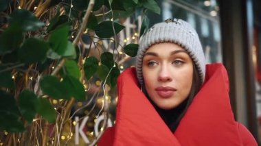 Kırmızı kış ceket güzel kadını bir güzel eski Avrupa şehirde kar ile kaplı cadde boyunca yürür